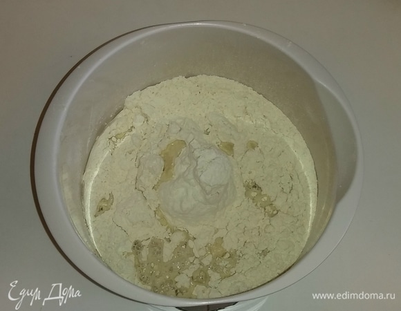 В глубокую емкость высыпаем просеянную муку, затем выливаем туда кипяченую воду комнатной температуры и после этого добавляем соль. Начинаем перемешивать ингредиенты столовой ложкой, а затем уже мешаем тесто руками до образования шара, который хорошо отделяется от стенок емкости и не липнет к рукам.