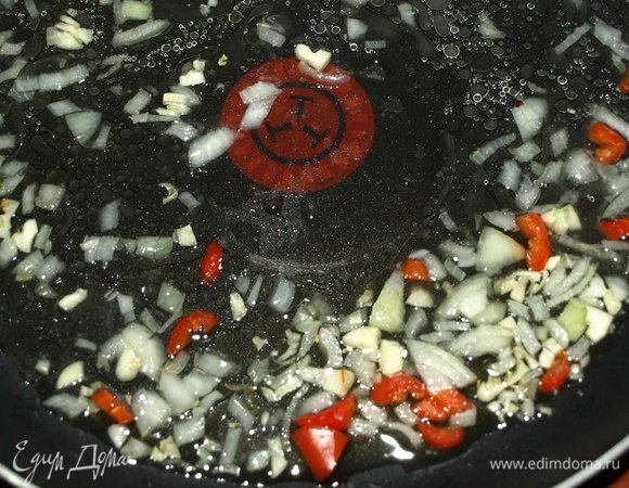 Лук, чеснок мелко нашинковать. Часть острого красного перца мелко нарезать. Перец лучше взять небольшой. Обжарить на разогретой с растительным маслом сковороде 1 минуту.