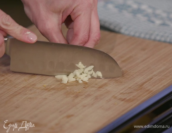 Два зубчика чеснока почистить, раздавить плоской стороной ножа и мелко порубить.