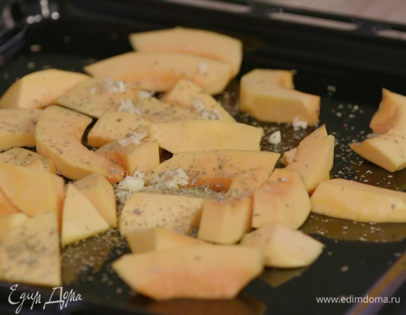 Нарезанную тыкву выложить на противень в один слой, посыпать чесноком, 1/4 ч. ложки майорана, слегка сбрызнуть оливковым маслом, посолить, поперчить и запекать в разогретой духовке 10 минут.