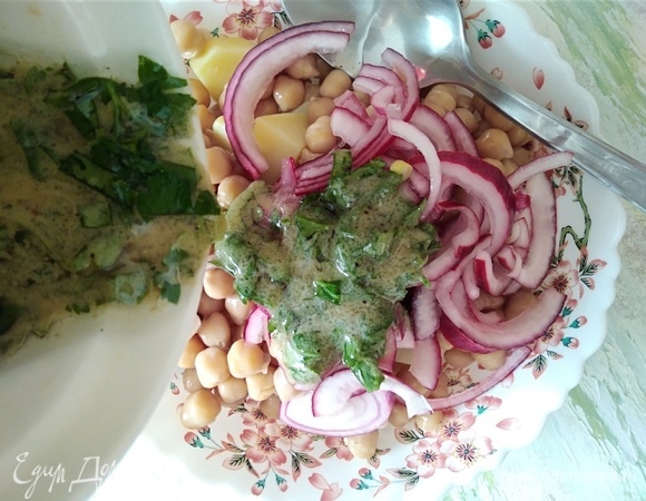 Соединить нут, картофель и лук. Залить заправкой и перемешать. Переложить в салатник.