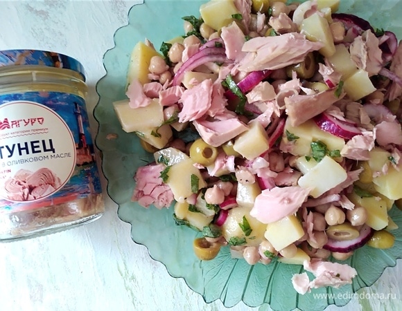 Разложить кусочки тунца и оливки.