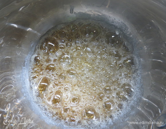 Готовим ореховую карамель. Орехи измельчить и выложить на силиконовый коврик. В толстостенный сотейник всыпать сахар, стараясь, чтобы по краям было чуть меньше сахара, чем в середине. На среднем огне, не помешивая, а лишь при необходимости покачивая сотейник из стороны в сторону нерезкими круговыми движениями, дождаться расплавления сахара.