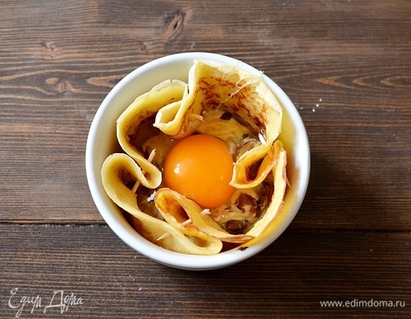 Аккуратно вбейте яйцо. Запекайте в разогретой до 180°C духовке до желаемой консистенции яичницы.