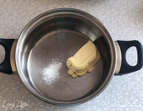 В кастрюлю положить сливочное масло, добавить соль, влить стакан воды и поставить на огонь.