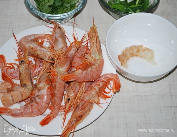 Очистите креветки, положите их в тарелку, удалив жилки, отложите в сторону. Панцири креветок промойте холодной водой.