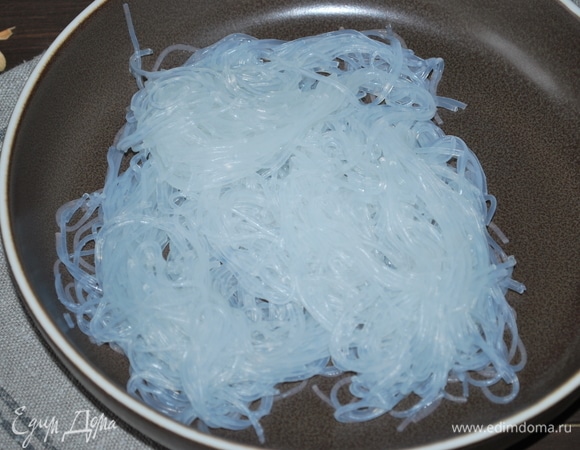 В тарелки положите рисовую лапшу и налейте горячий суп.