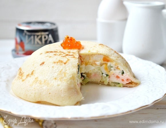 Переверните торт на тарелку, уберите пленку, украсьте икрой и подавайте к столу.