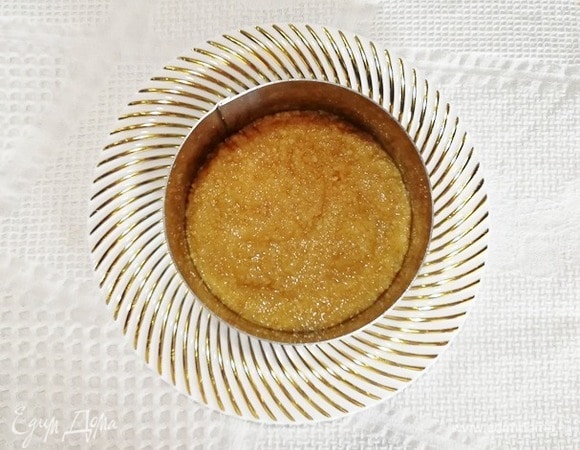 Я сразу взяла тарелку для подачи. Устанавливаем на нее кулинарное кольцо и утрамбовываем основу. Убираем основу в холодильник, пока приготовим начинку.