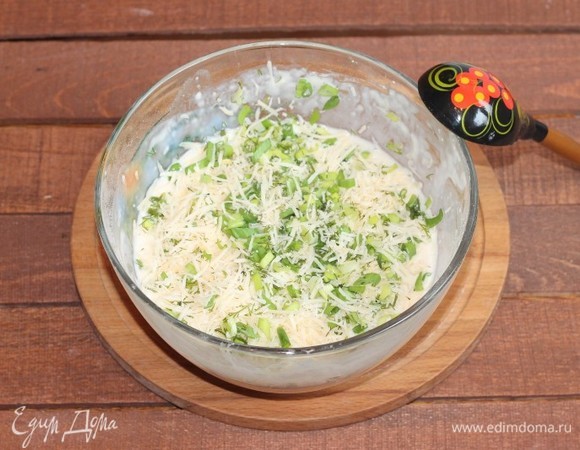 В блинное тесто добавляем тертый сыр, зелень, прессованный чеснок и 2 столовые ложки растительного масла, все хорошо перемешиваем.