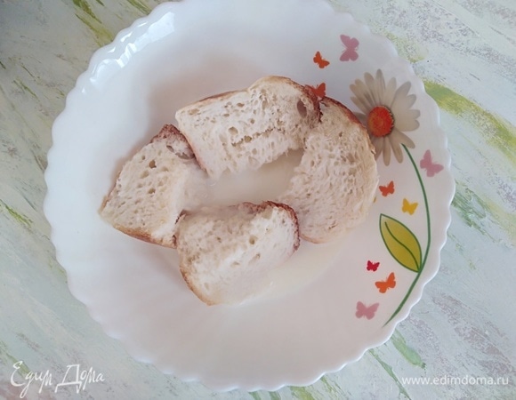 Пока перчики запекаются, приготовим начинку. Хлеб замочить в молоке на 10 минут. Затем молоко отжать, а хлеб раскрошить руками.