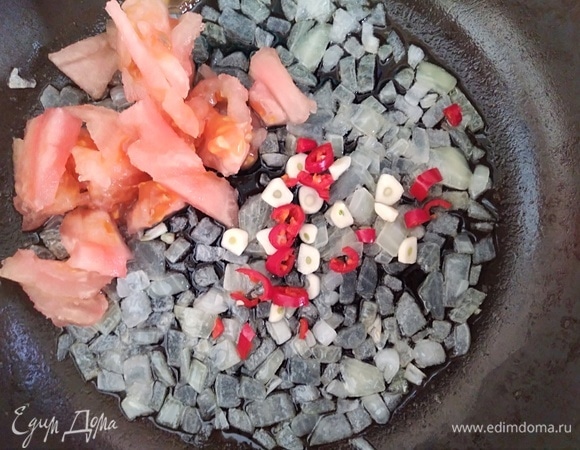 Через 2–3 минуты добавить нарезанный острый перчик (у меня был маленький), нарезанный чеснок и помидор без кожицы. Готовить, помешивая, 3 минуты.