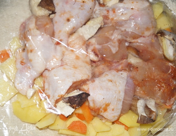 Равномерно выложите нарезанный средними дольками картофель, морковь и лук на дно рукава, сверху — любимые специи. Далее одним слоем разложите куски курицы. Курицу заранее нарежьте на порции, замаринуйте (не менее 3 часов или целую ночь в холодильнике) в домашней аджике с чесноком, посолите по вкусу, специи любимые добавьте. Между кусочками курицы разложите нарезанные на ломтики белые грибы. У меня грибы были замороженные. Я их просто промыла в воде.