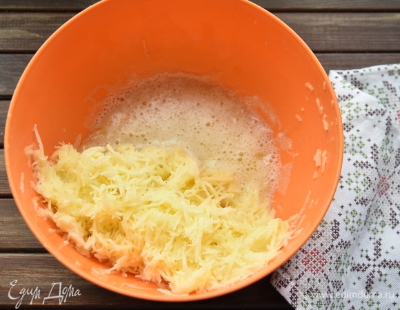Картофель натереть на мелкой терке, отжать лишнюю влагу. Жидкость слить, оставив отстоявшийся на дне емкости картофельный крахмал. На терке натереть репчатый лук и чеснок. Можно их мелко нарезать или измельчить в кухонном комбайне.