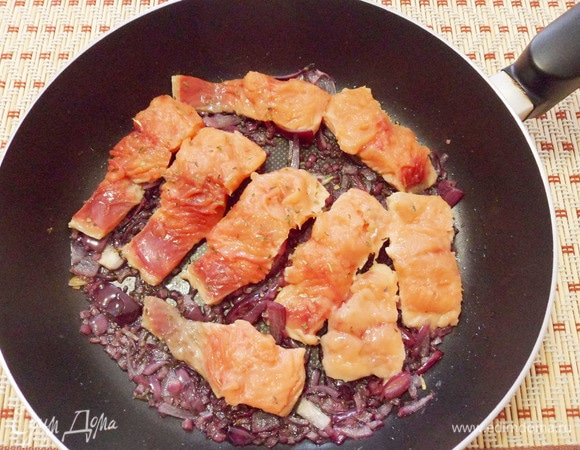 Нарезать филе горбуши совершенно произвольно. Затем обжарить его в сковороде с луком сначала с одной стороны.