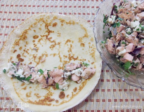 Выложить рыбную начинку на блинчик. Свернуть рулетом.