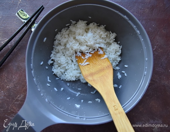 Смешать рисовый уксус, соль и сахар. Чтобы легче растворить соль и сахар, уксус можно слегка подогреть в микроволновке (10 секунд). Влить смесь в рис и деревянной лопаткой аккуратно перемешать.