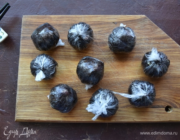 Таким образом сформировать все шарики. Дать заготовкам полежать минуты 2–3. Затем раскрутить пленку и снять. Выложить шарики на доску швом вниз.