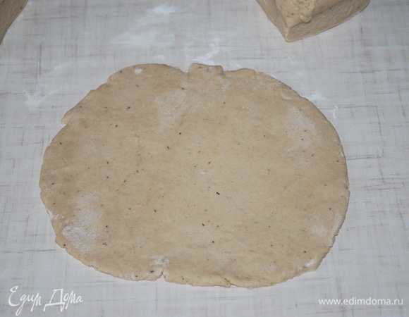 Раскатайте тонкий сочень. Переложите его на пекарскую бумагу.