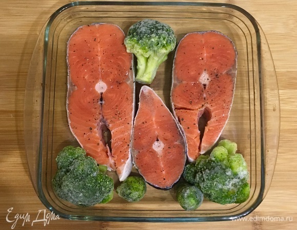 В форму для запекания выложить стейки кижуча и несколько соцветий брокколи. Рыбу посолить и поперчить.
