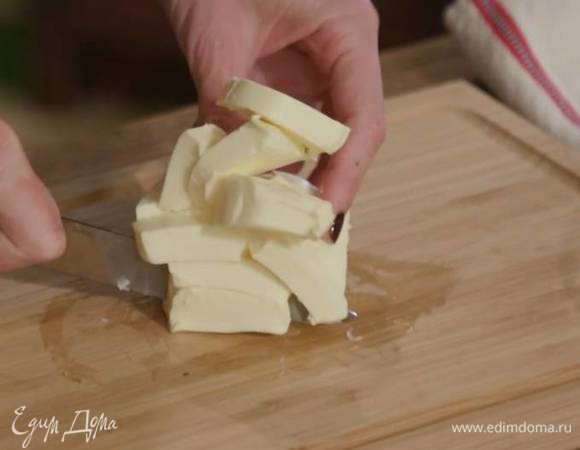 Предварительно охлажденное сливочное масло нарезать небольшими кусочками.