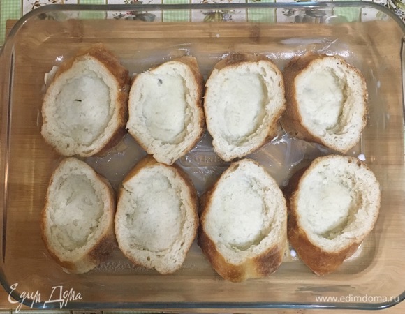 Форму для запекания смазать сливочным маслом, выложить кусочки хлеба. Сделать углубление (удобно чайной ложкой) и выложить начинку по одной столовой ложке.