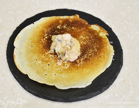 На середину блина выложите немного начинки.