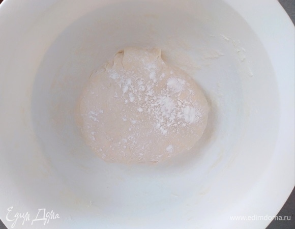 Когда тесто соберется в шар, месить еще 10 минут руками. Миску посыпать мукой и поместить в нее тесто. Накрыть крышкой или пленкой и оставить на расстойку на час.