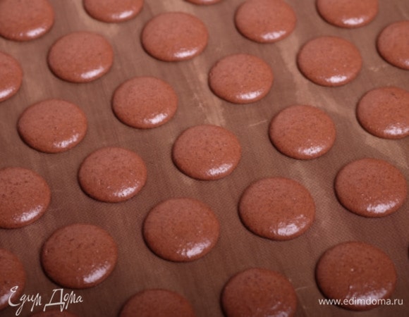 И отсадить аккуратные кружочки будущих половинок. Чтобы освободить макарон от воздушных полостей и сравнять «хвостики», нужно постучать противнем по столу или другой поверхности.