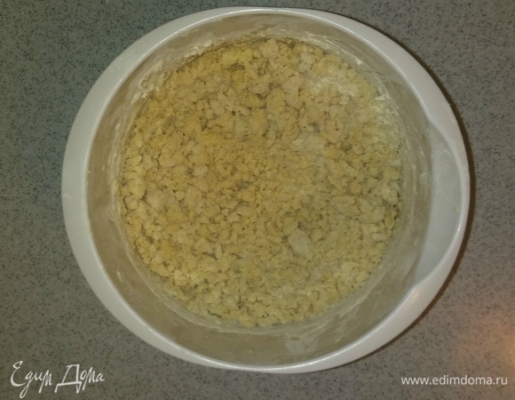 Затем добавляем в эту емкость просеянную муку и миксером перемешиваем до образования крошки из теста.