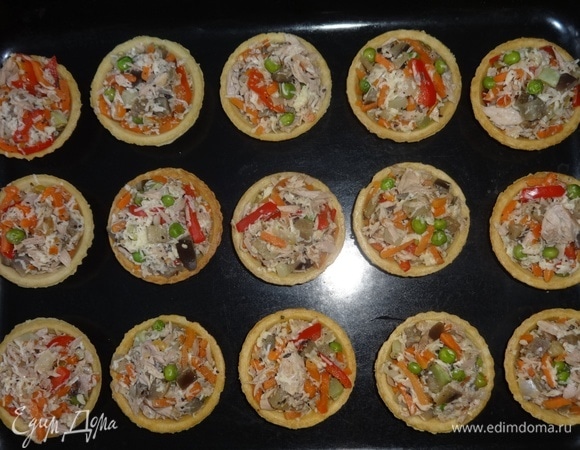 Начинить тарталетки рыбно-овощной смесью, выложить на противень и поставить в духовку, разогретую до 180°C, на 5–7 минут. Зеленый лук вымыть, обсушить, мелко нарезать.