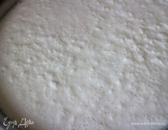 Добавить йогурт, перемешать. Поставить кастрюлю с молоком на медленный огонь, постоянно помешивать. Нагреть до температуры примерно 80–90°C. Не доводить до кипения. Молоко начнет сворачиваться, и будут образовываться творожные сгустки, которые отделяются от сыворотки.