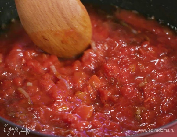 Не снимая сковороду с огня, добавить соевый соус, сахар и измельченные томаты в собственном соку, перемешать.