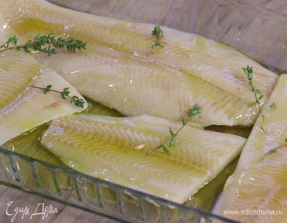 Выложить филе палтуса в форму для запекания, полить небольшим количеством оливкового масла и добавить несколько веточек тимьяна.