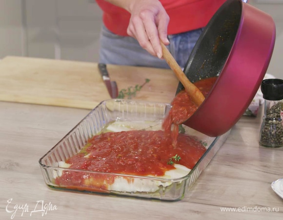 Залить рыбу томатным соусом и выпекать в духовке 5–7 минут.