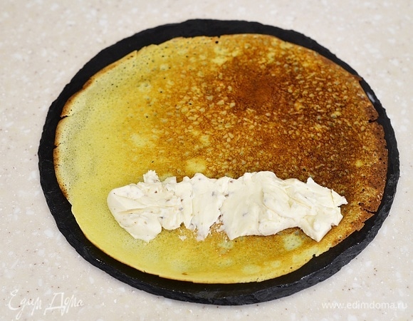 Край каждого блина смажьте плавленым сыром.