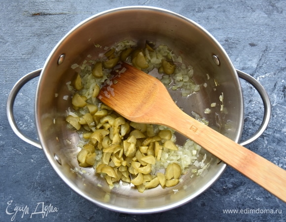 Добавила рубленые соленые огурцы, немного потомила их с луком на среднем огне.