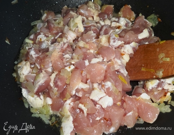 Добавить куриное мясо, жарить на небольшом огне, помешивая до готовности курицы.