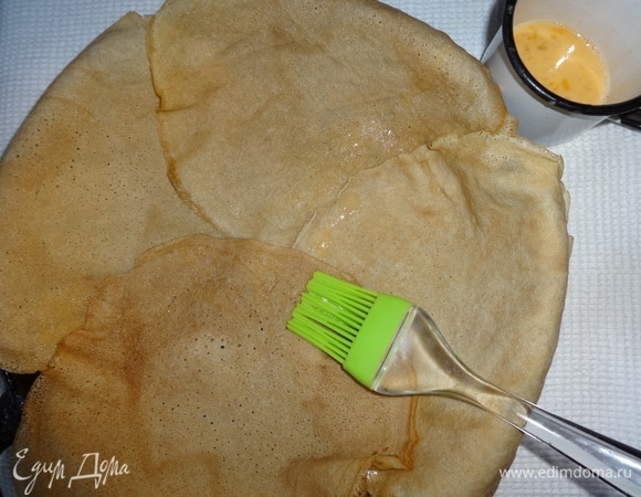 Дно и бока формы смазать растительным маслом. Положить внахлест по кругу 4 блина, чтобы края свисали, стыки смазать размешанным яйцом