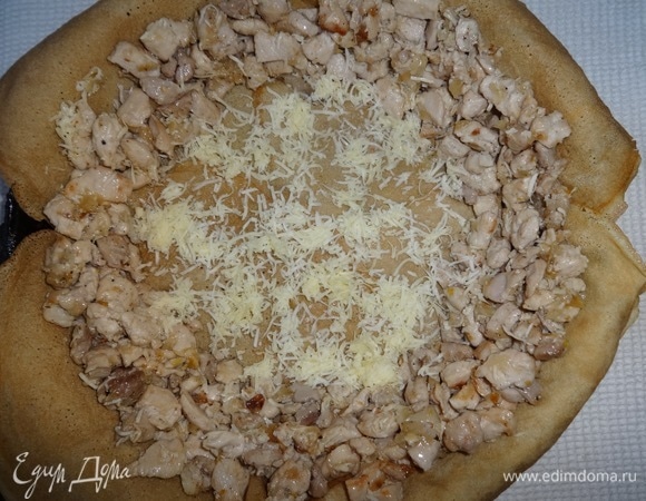 По краю формы выложить начинку из курицы в виде кольца. Незаполненное пространство посыпать сыром.