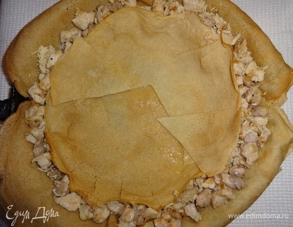 На сыр положить 2 блинчика, один из которых оставить целым, а второй разрезать на части, чтобы закрыть курицу (края надрезать, чтобы получились бортики).