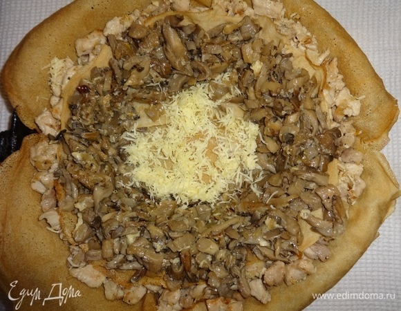 Распределить на нем грибную начинку в форме кольца. Дно посыпать сыром.