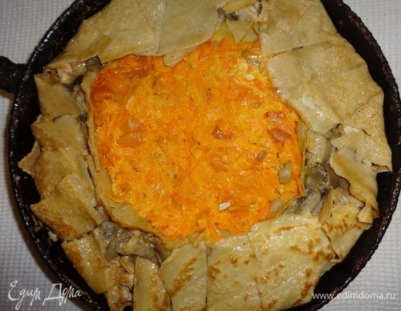 Выложить начинку из моркови и кураги. Свисающие края блинчиков надрезать и завернуть внутрь, смазать взбитым яйцом.