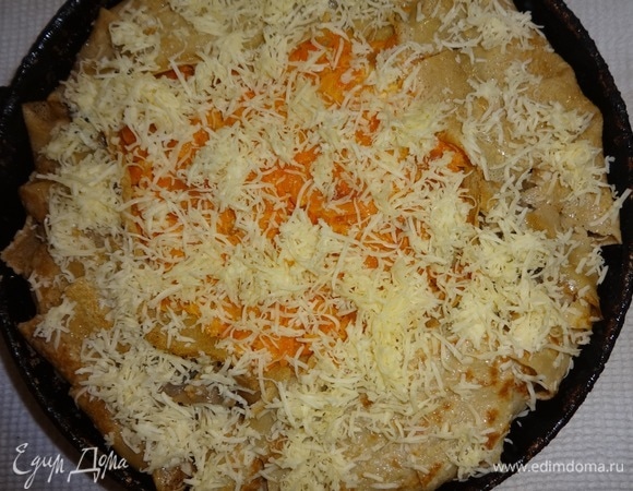 Посыпать всю поверхность пирога половиной сыра.