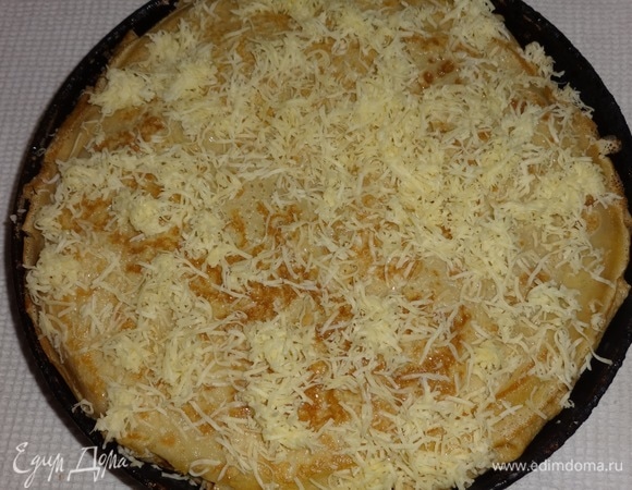 Посыпать верх пирога оставшимся сыром. Поставить пирог в горячую духовку (210–220°C) на 10 минут.