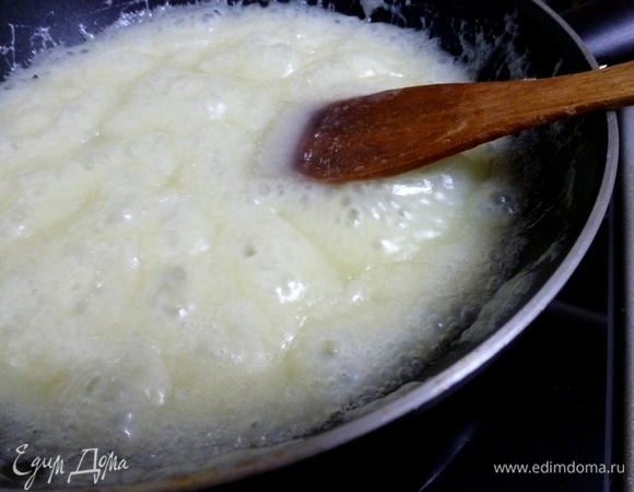 Смешать сахар со сметаной и нагревать на глубокой сковороде.