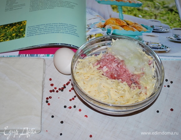 Я взяла 2 пласта слоеного бездрожжевого теста. Фарш у меня из свинины и курицы. Все мясо вместе с луком измельчите в мясорубке. Твердый сыр натрите на терке. К мясу добавьте сыр, горчицу, соль и перец, хорошо перемешайте фарш.