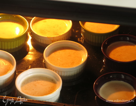 Предварительно разогреть духовку до 170°C с противнем с горячей водой. Поставить формочки в воду, чтобы они были на 1/2 в воде. Прогревать 60–70 минут.