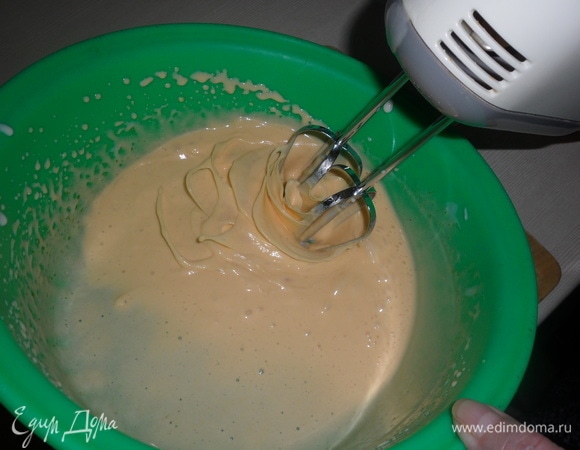 Непрерывно взбивая миксером, порциями ввести во взбитые желтки половину соуса.