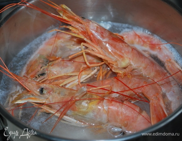 Когда вода с рыбой закипит, креветки окуните в рыбный бульон и проварите креветки вместе с рыбой в течение двух минут.